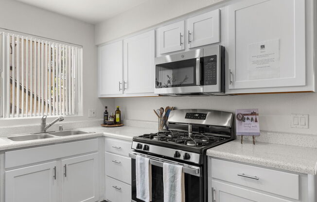 a kitchen with a stove a sink and a microwave