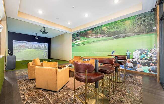 A room with a large screen and a bar area.