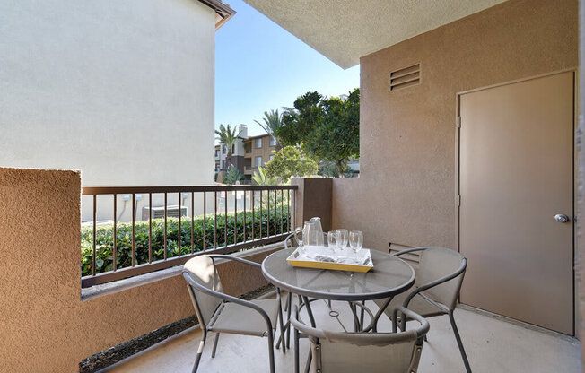 A balcony with a table and chairs is set for two.