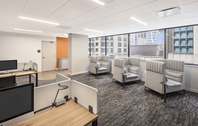 a lounge area with chairs and tables and a tv