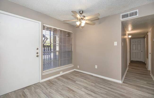 A room with a ceiling fan and a door.