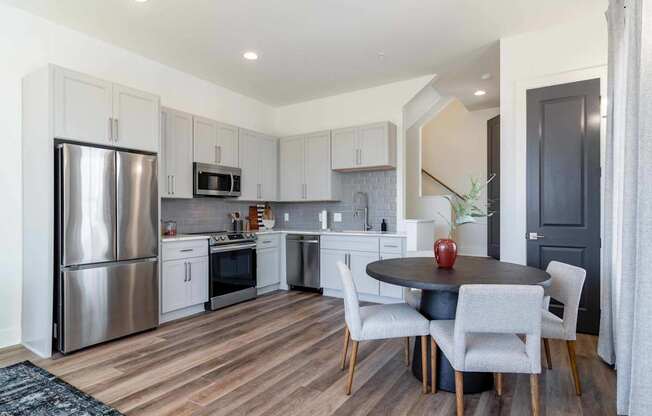A modern kitchen with a dining table set for two.