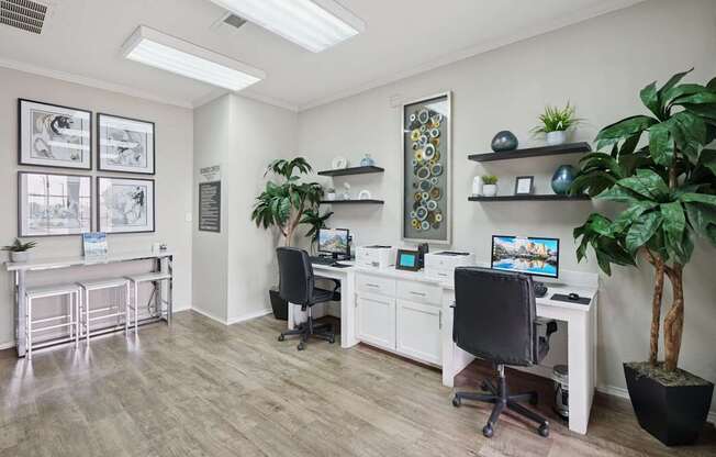A business center with computers, printers, and potted plants at Jefferson Place Apartments in Irving, TX