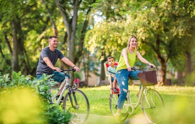 a man and woman riding bikes with a child on the back