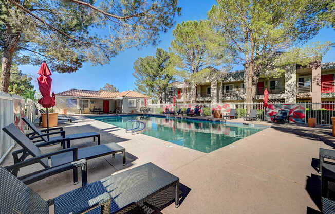 A pool area with lounge chairs and umbrellas.