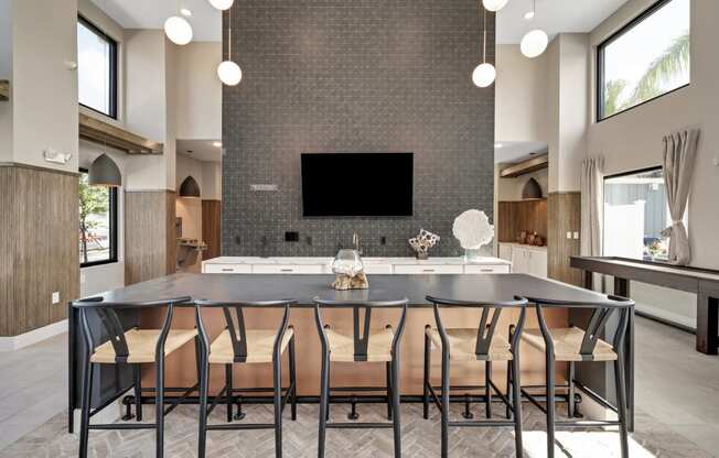 a large dining table with chairs in front of a kitchen with a large tv on the wall  at The Sophia, Venice, Florida