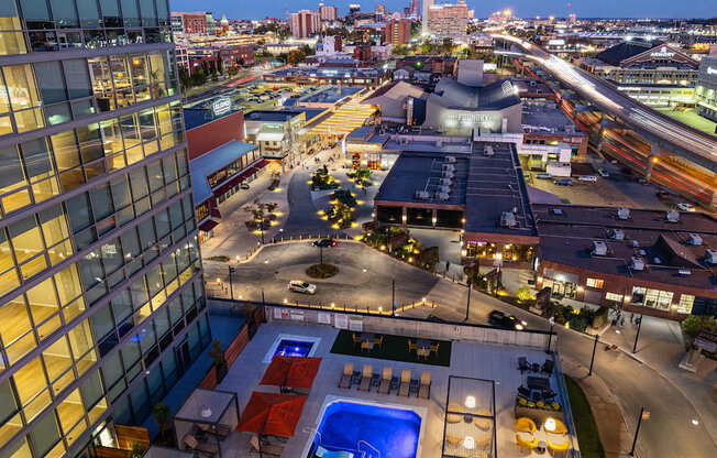 A rooftop pool area with a view of the city at dusk.