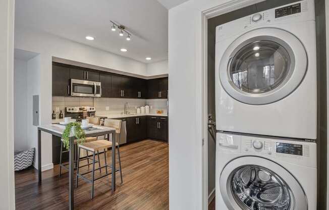 A modern kitchen with a washer and dryer built into the cabinetry.