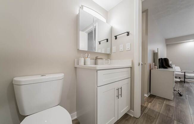 A white toilet sits next to a white sink in a bathroom.