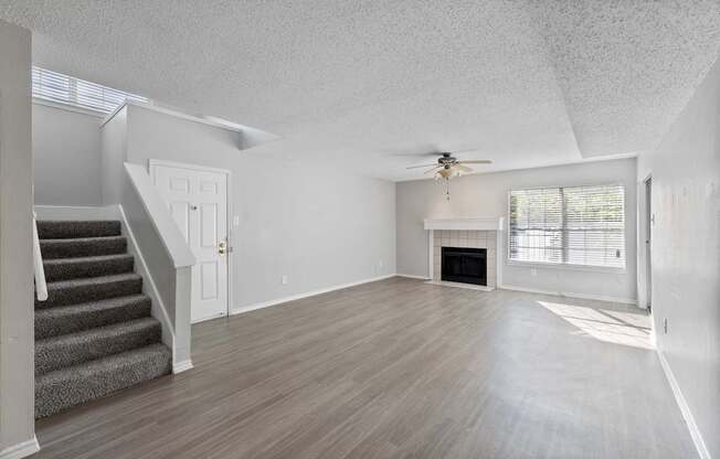 A spacious living room with a staircase leading to the upper floor.