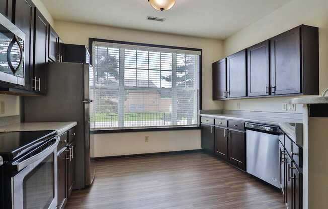 A kitchen with black cabinets and stainless steel appliances.