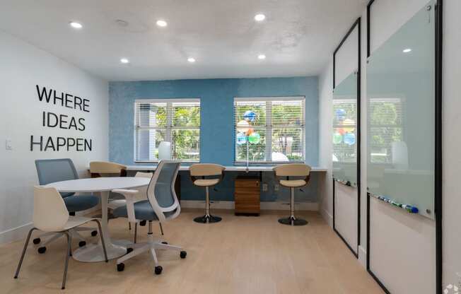 a conference room with a table and chairs and a window at Aqua Bay Apartments in Naples, FL 34116