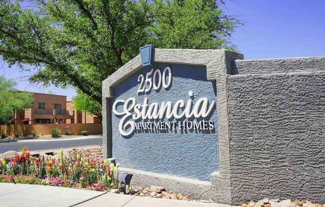 A sign for Estancia Apartment Homes is shown in front of a building.