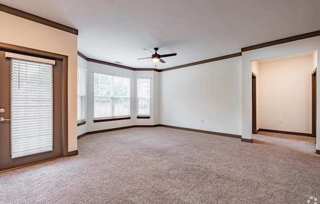 A room with a ceiling fan and a carpeted floor.