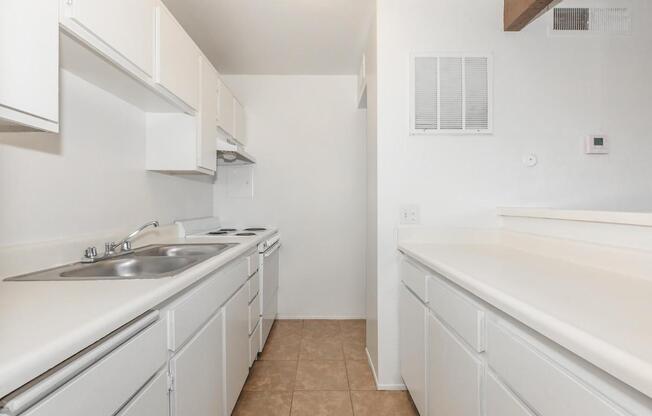 a kitchen with white cabinets and a sink