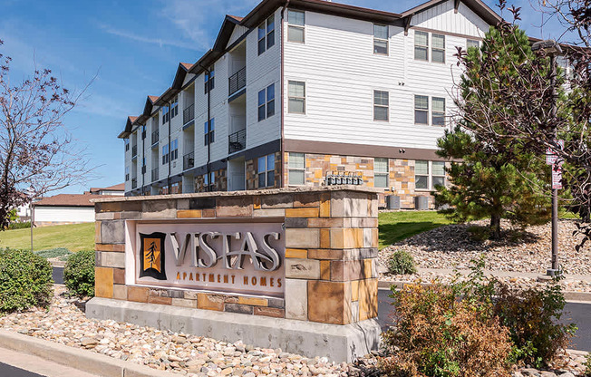 A Vista Apartments building with a stone entrance sign.