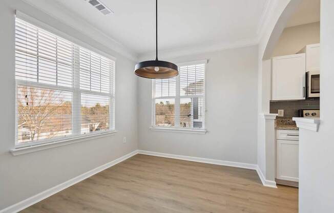 A room with a large window and a hanging light fixture.