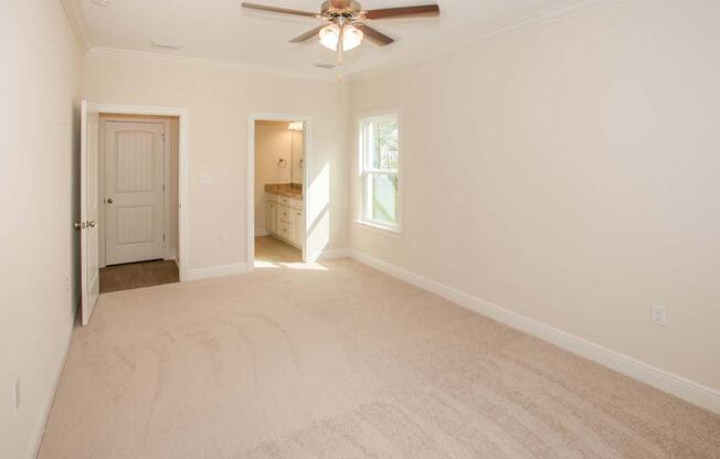 an empty living room with a ceiling fan