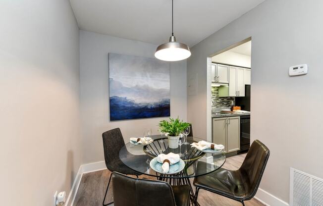 a dining room with a glass table and four chairs