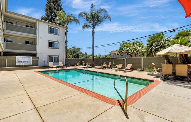 A swimming pool surrounded by a concrete floor and chairs.