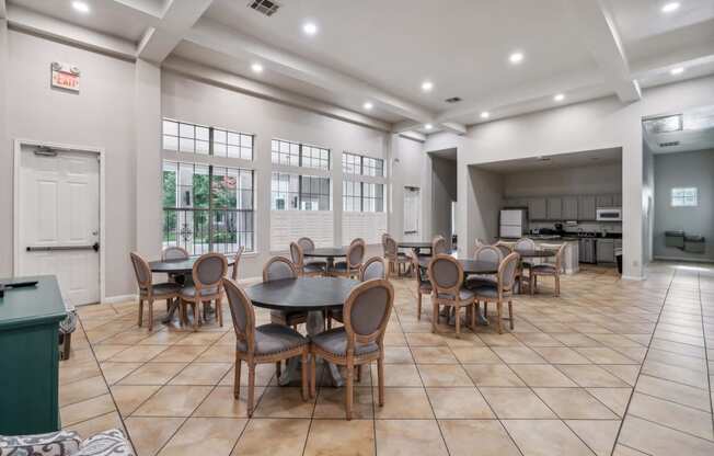 a dining area with tables and chairs and a kitchen in the background at St. Augustine Estate, Dallas, Texas