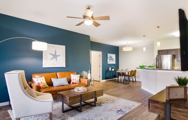 a living room with blue walls and a ceiling fan