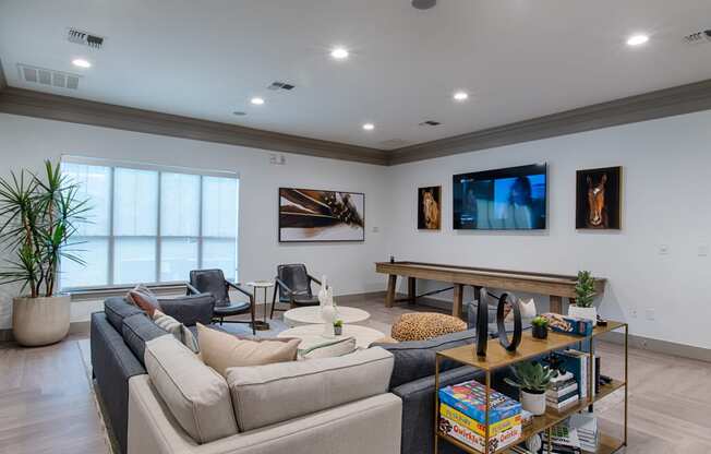 Seating area with couch, flat screen TV and coffee tables