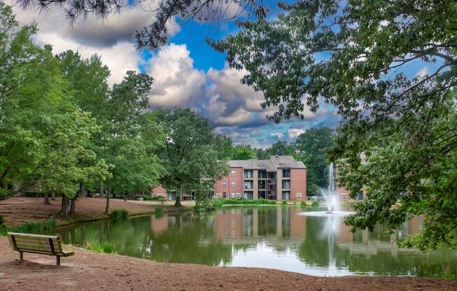 a pond with a fountain and a building in the background at The Summit Apartments, Tennessee, 38128