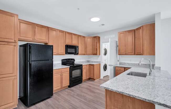 a kitchen with wooden cabinets and a black refrigerator