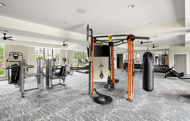 a gym with weights and cardio equipment in a building with windows