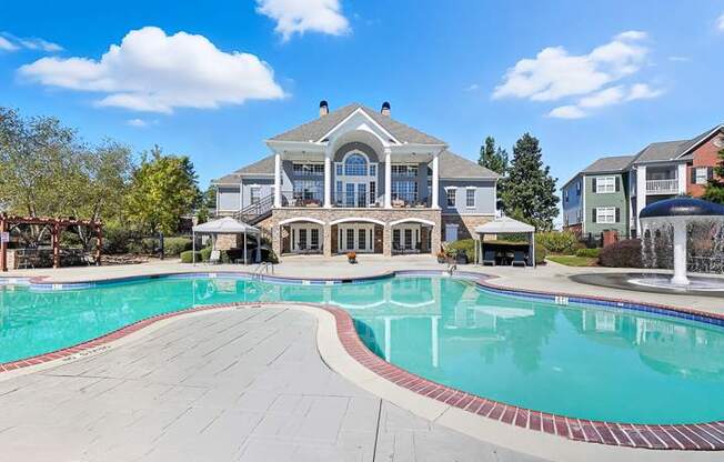 A large house with a pool in front.
