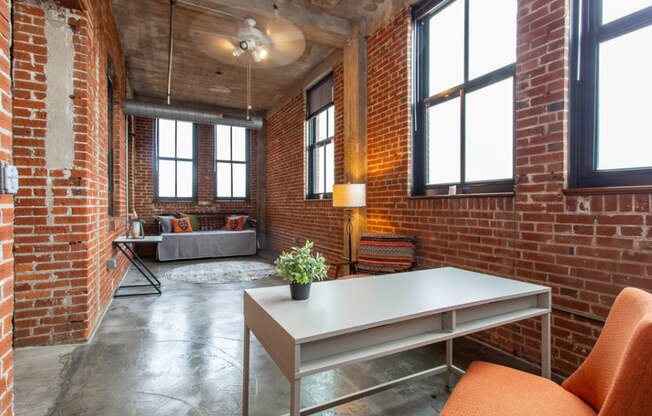 a living room with brick walls and a table and chairs