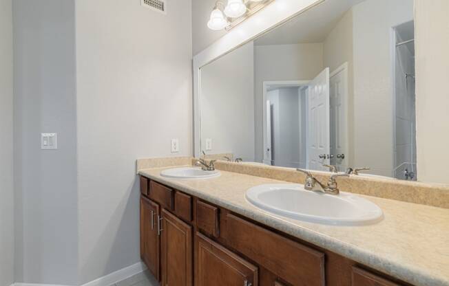 an empty bathroom with two sinks and a mirror