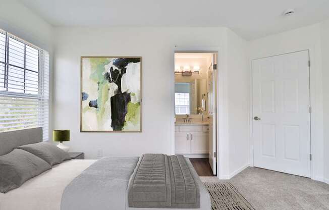 A bedroom with a large bed and a painting on the wall.