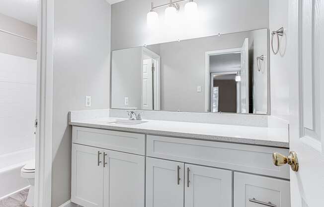 Bathroom with large mirror and storage at Parkside at Sandy Springs Atlanta, GA