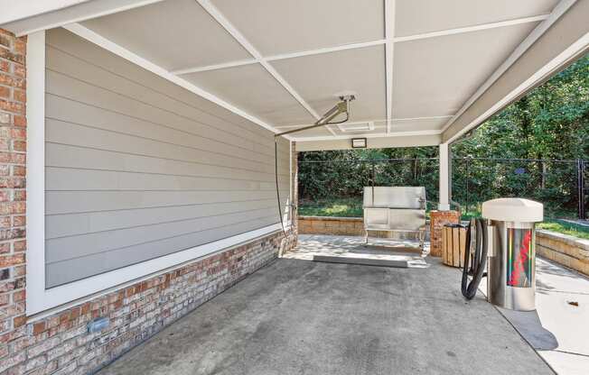 a covered patio with a grill and a heater on it