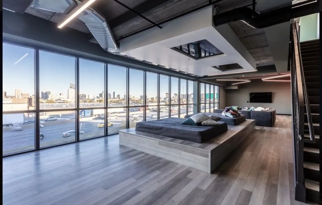 a bedroom with a couch and a bed in a room with floor to ceiling windows