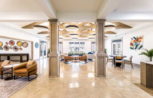 the lobby of a hotel with tables and chairs and a fireplace at The Parker Austin, Pflugerville, TX