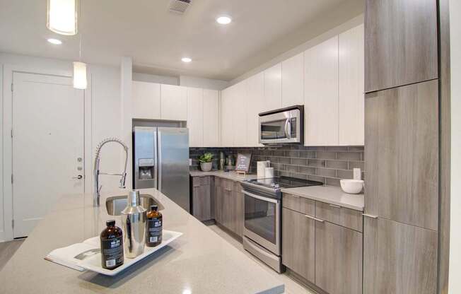 A kitchen with a white countertop and stainless steel appliances.