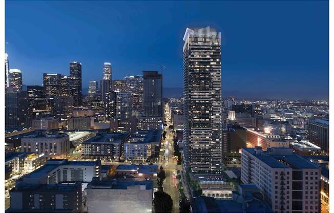 A cityscape at night with a tall building in the foreground.