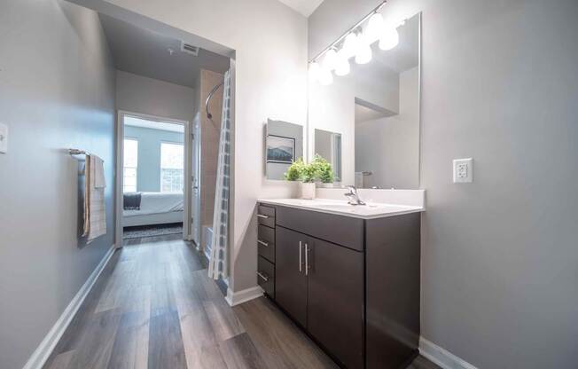 A bathroom with a vanity, mirror, and lights at Harbor Pointe, Bayonne
