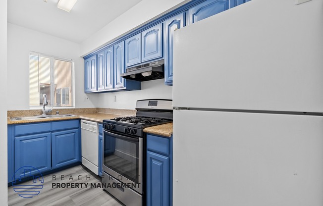 a kitchen with blue cabinets and a stove and refrigerator