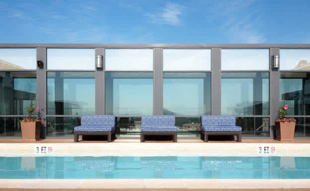 a building with a swimming pool in front of it at The Millennium, Arlington