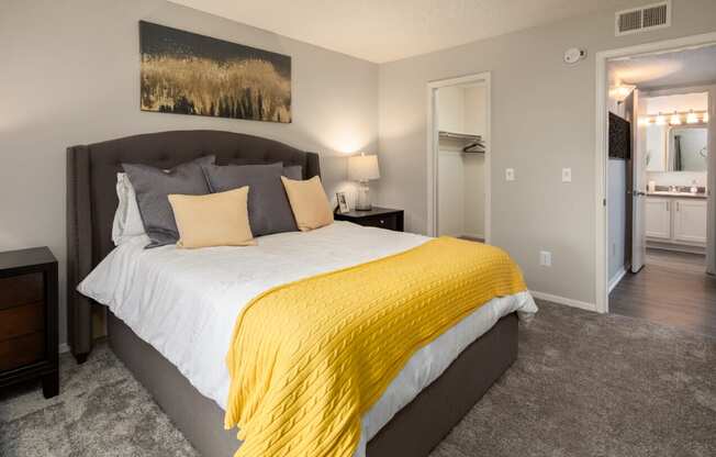 a bedroom with a large bed and a yellow blanket