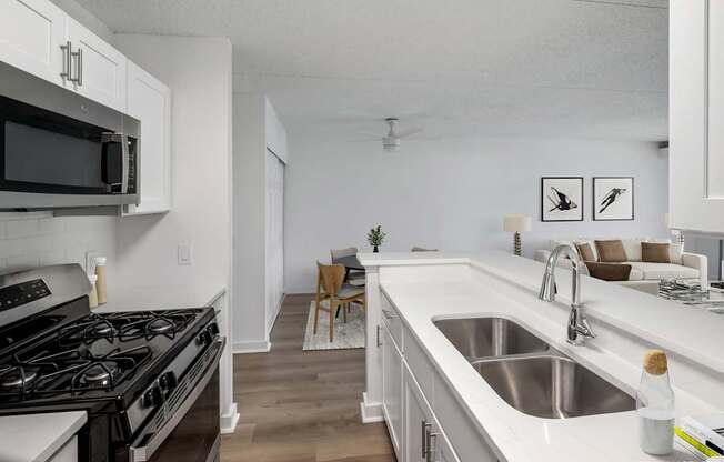 Model, modern kitchen with a stove top oven and white cabinets.