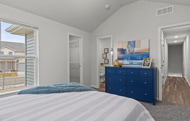 a bedroom with a bed and a blue dresser