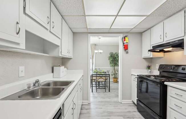 A kitchen with white cabinets and a black stove top oven.