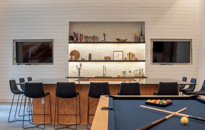 A pool table with a cue and balls in the middle of it.