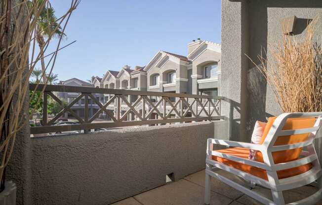 model balcony with views of the community and an orange chair