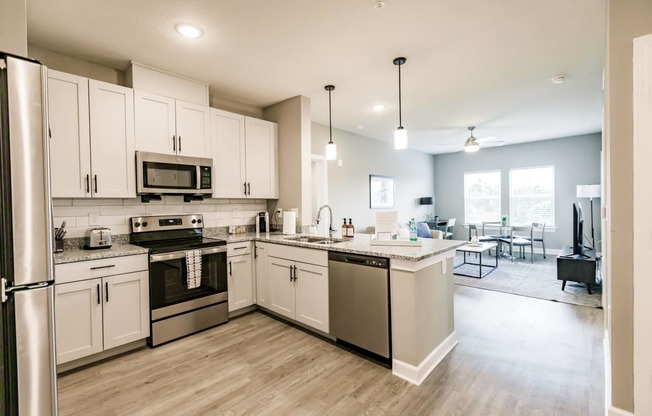 a kitchen with stainless steel appliances and white cabinets at Vantage Luxury Apartments in Cape Coral, FL